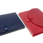 A blue and a red plastic accordion folder with button-and-string closures, designed for durability, are placed on a white surfaceโideal examples of products from Manufacturing Stationery Items in China.