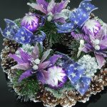 A decorative wreath with pinecones, green foliage, purple ornaments, silver accents, and purple ribbon bows on a black background.