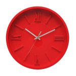 A red wall clock with Roman numerals and silver hour and minute hands, showing the time as 6:05.