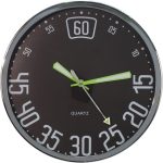 Round wall clock with a black face, large white numerals in multiples of five, and green hour and minute hands pointing to 12 and 25, respectively.