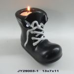 A black boot-shaped candle holder with white laces holds a lit tealight candle. Product code JY29003-1 and dimensions 13x7x11 are displayed below.