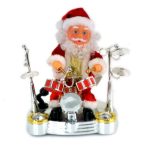 Toy Santa Claus dressed in red and white playing a miniature drum set with cymbals, on a white background.