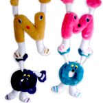 Plush toys shaped like the letters N, M, and O, each with cartoonish eyes, arms, and legs, arranged vertically on a white background.