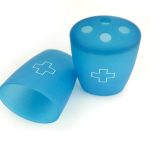 Two blue plastic cups with white medical cross symbols; one is upright with holes on top, the other is lying on its side.