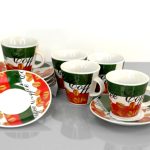 A set of five coffee cups with matching saucers, featuring a green, red, and white design with coffee bean illustrations and the word "coffee" written on them.