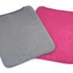 Two rectangular neoprene sleeves, one grey and one pink, both with a white abstract floral pattern, lying side by side on a white background.