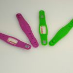 Two pink and two green plastic wristbands labeled "IMPORTANT ID" and "HYDRANT ID" are arranged on a white surface.