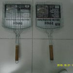 Sports Two metal grilling baskets with wooden handles are placed side by side on a tiled floor.