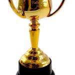 A gold trophy cup labeled "Melbourne Cup" with two handles, mounted on a black base, photographed against a white background.