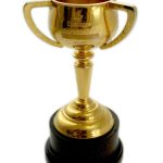 A gold trophy cup with two handles on a black base, standing against a white background.