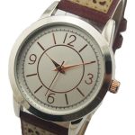 Analog wristwatch with a round silver case, white dial, brown hour markers and hands, and a brown strap with beige perforated detailing.