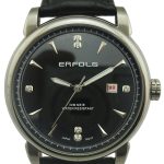 A round analog wristwatch with a black face, silver markers, "ERFOLG" branding, date display, and a black leather strap. The watch is labeled water-resistant.